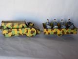 two toy soldiers riding on a toy truck on a white surface