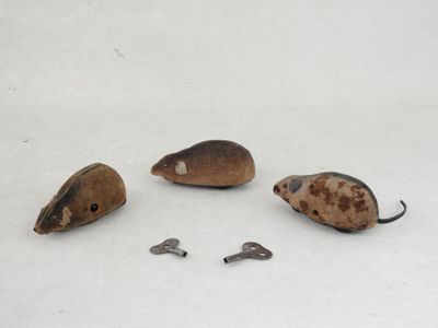three mice that are sitting on a white surface