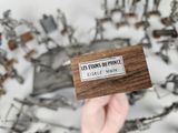 a person holding a business card in front of a bunch of metal objects