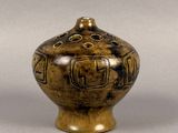 un vase marron orné d'un motif sur un fond gris