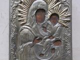 une image représentant une plaque métallique sur laquelle figure une femme tenant un enfant dans ses bras