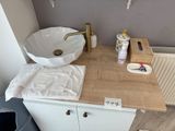 a white sink sitting on top of a wooden counter