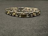 silver and gold plated bracelet on a black surface