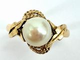 an image of a gold ring with a pearl in the center