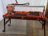 an orange and black table with a saw on top of it