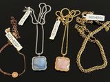 four different types of necklaces on a black surface