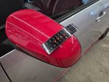 a red car door handle with a sticker on it