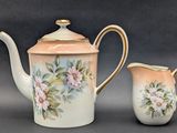 a tea pot and a creamer sitting next to each other