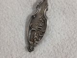 une cuillère en argent ornée d'un dragon, posée sur une table