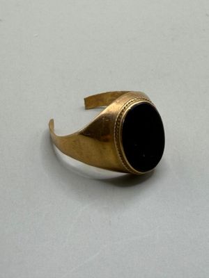 an image of a gold ring with a black stone in it