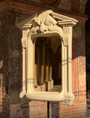 un miroir posé sur un pied devant un bâtiment