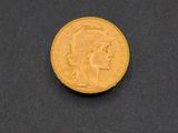 a close up of a gold coin on a black surface
