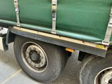 un camion vert garé sur le bord de la route
