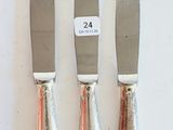 three knives that are sitting on a white surface