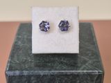 une paire de boucles d'oreilles en saphir bleu posées sur un bloc de marbre