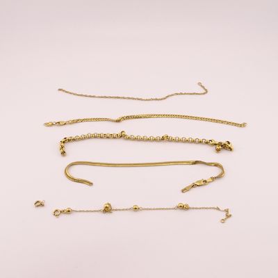 a collection of gold necklaces and bracelets on a white background
