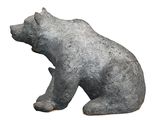 a statue of a bear sitting on a white surface