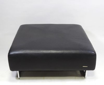 black leather ottoman with chrome legs on a white background