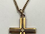 gold tone cross pendant with a chain on a mannequin mannequin mannequin mannequin mannequin mannequin mannequin manne