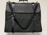 un sac noir accroché au mur, muni d'une poignée