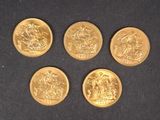 quatre pièces d'or sont disposées en cercle sur une surface noire