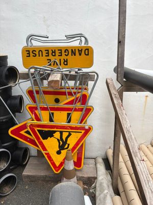 un tas de panneaux de signalisation au pied d'un immeuble