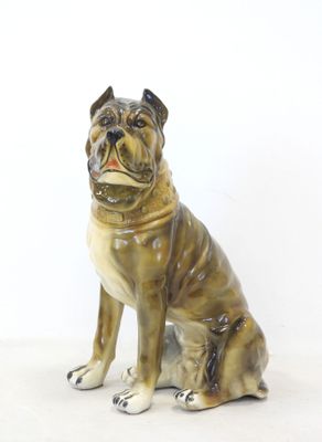 a figurine of a dog sitting on a white surface