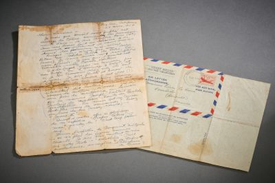 Une vieille lettre et une enveloppe sont posées sur une table