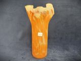 an orange vase that is sitting on a gray surface