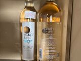 two bottles of wine sitting next to each other on a shelf