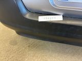 a sticker on the bumper of a car that is parked in a garage
