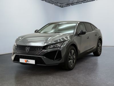 une voiture grise garée dans une grande pièce aux murs blancs