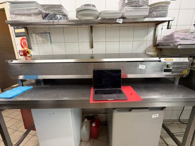 un ordinateur portable posé sur une table dans une cuisine