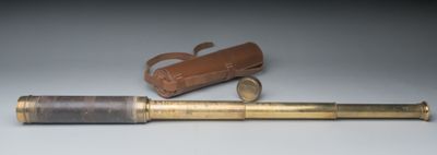 un vieux télescope en laiton avec un étui en cuir et un étui en cuir