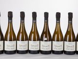 six bouteilles de vin sont alignées sur une table