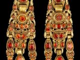 deux paires de boucles d'oreilles en verre doré et rouge sur fond noir