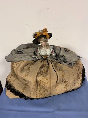 une figurine représentant une femme assise sur un oreiller