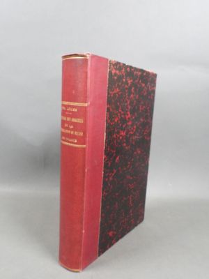 an old book with a red cover sitting on top of a table