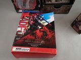 the box is open on the table with the action figure next to it