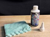 a bottle of liquid and a cloth on a table