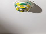 un plafond blanc sur lequel brille une lumière jaune et verte