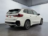 a white bmw suv parked inside of a building
