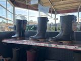 trois paires de bottes de pluie sur une étagère dans un magasin