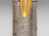 an antique silver and gold vase with a bird on top