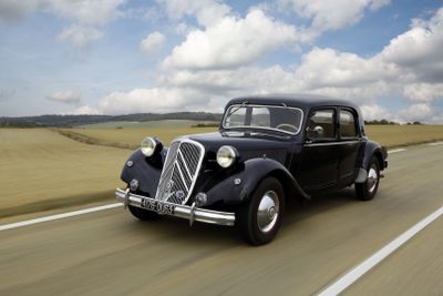 a black car driving down the road on a cloudy day