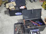 une boîte à outils noire contenant des outils, dans un garage