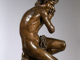 bronze statue of a man sitting on a pedestal with his hand on his chin