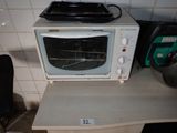 a microwave sitting on top of a table next to a chair