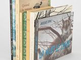 trois livres sont empilés sur une surface blanche