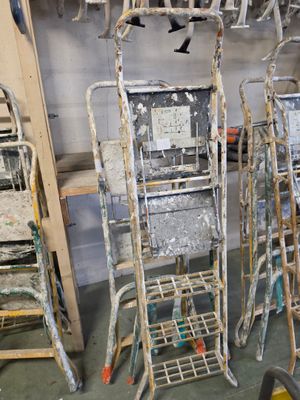 beaucoup de chaises et d'échelles qui se trouvent dans une pièce